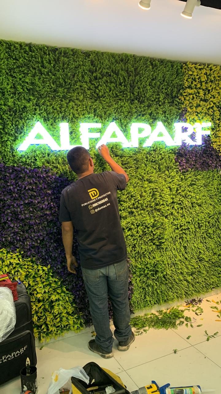Instalador de DOMAC instalando un letrero iluminado para Alfaparf