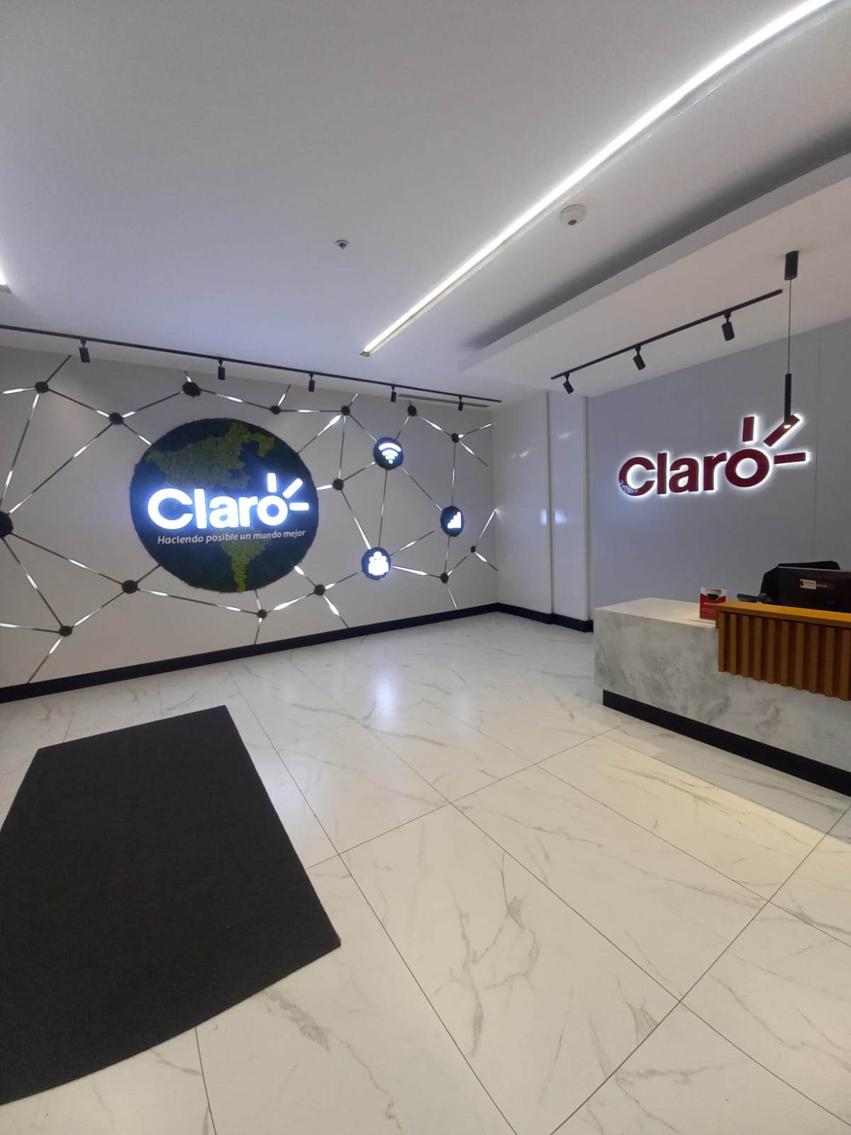 Recepción corporativa de Claro con letrero corpóreo y pieza de branding de espacio fabricados por DOMAC